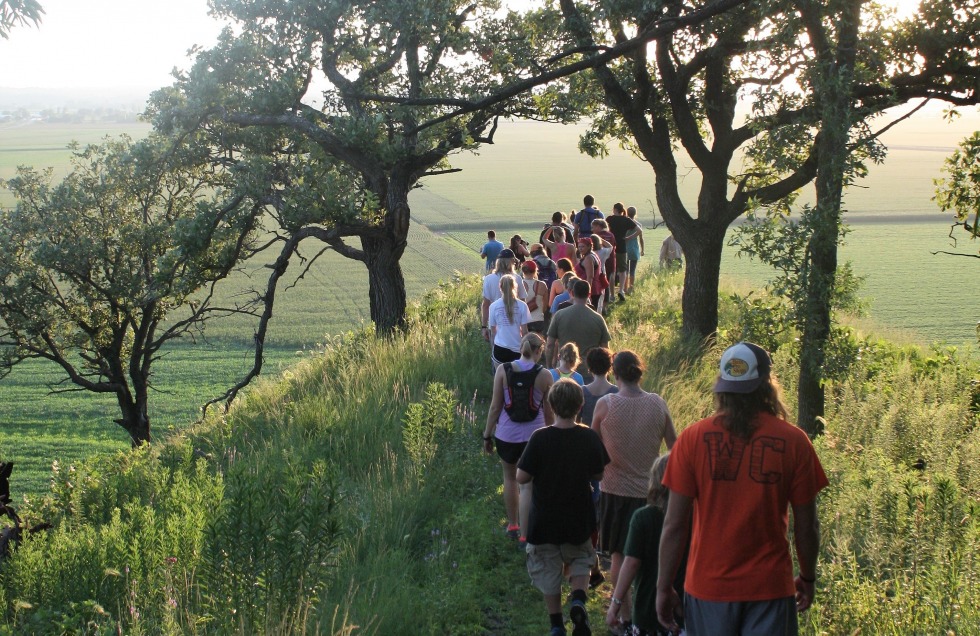 A large group of hikers overlook scenic surroundings at Hitchcock Nature Center