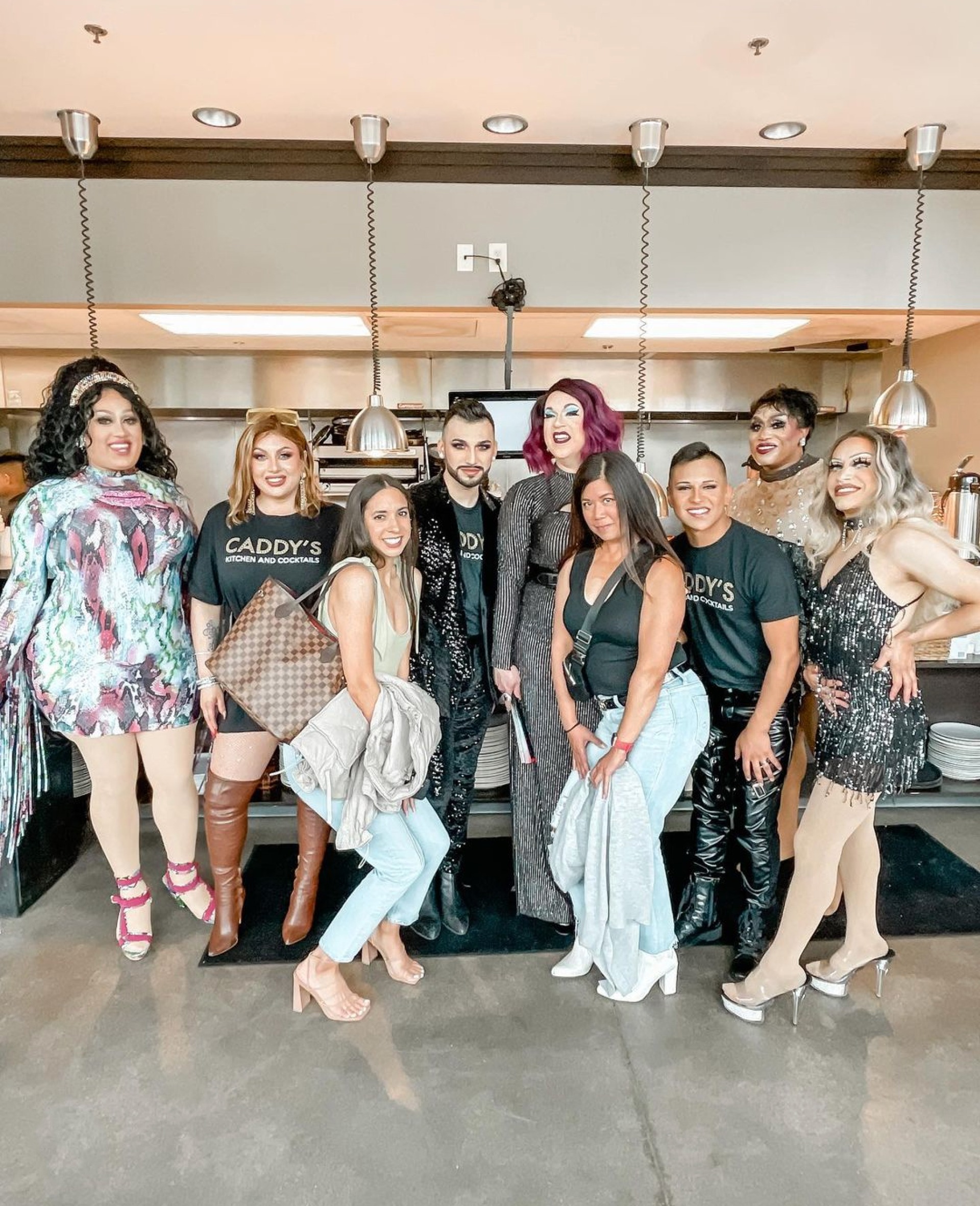 Two women standing with the Drag Yourself to Brunch cast at Caddy's Kitchen & Cocktails