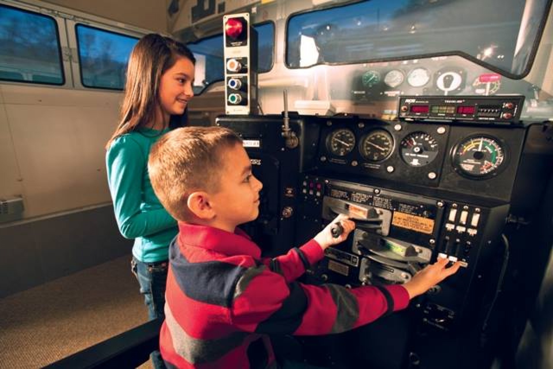Two children playing with the train simulator at the UP Museum
